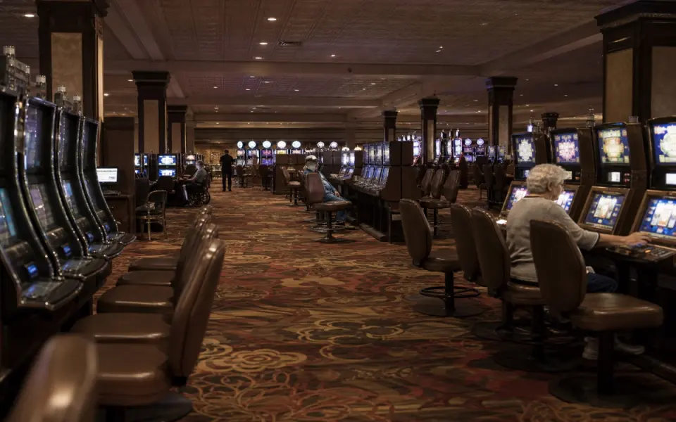 Illustration: a casino floor on a weekday morning, most seats at the slot banks empty