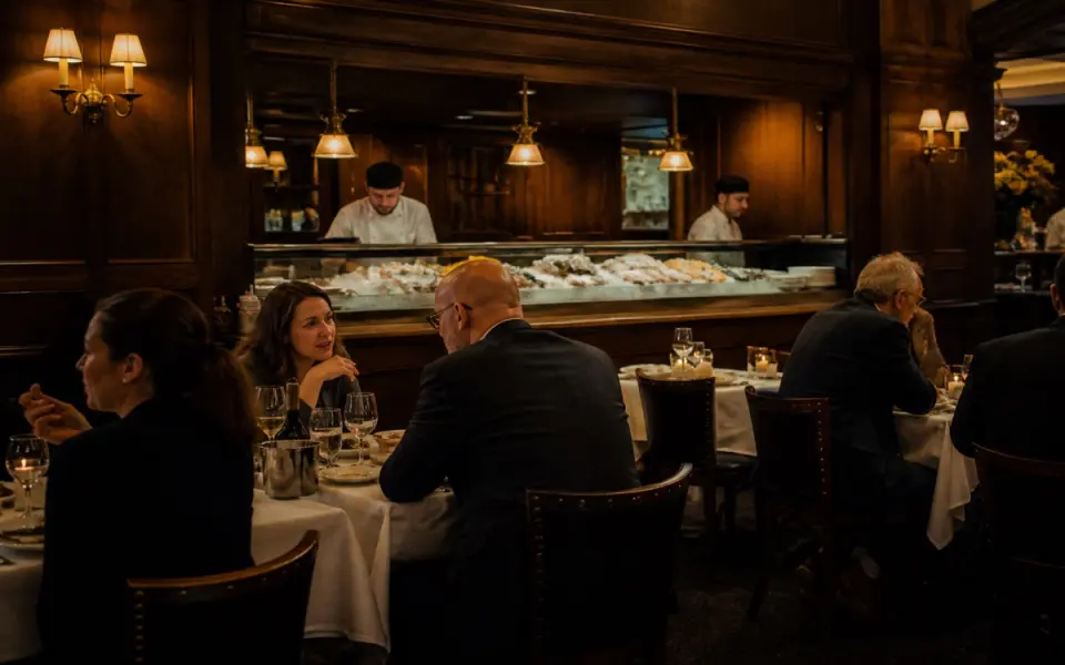 Illustration: the dining room of an old American oyster house, dark panelling and white tablecloths